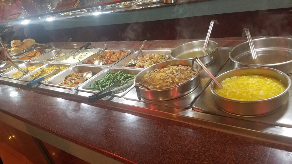 Counter service area with food pans and serving spoons.